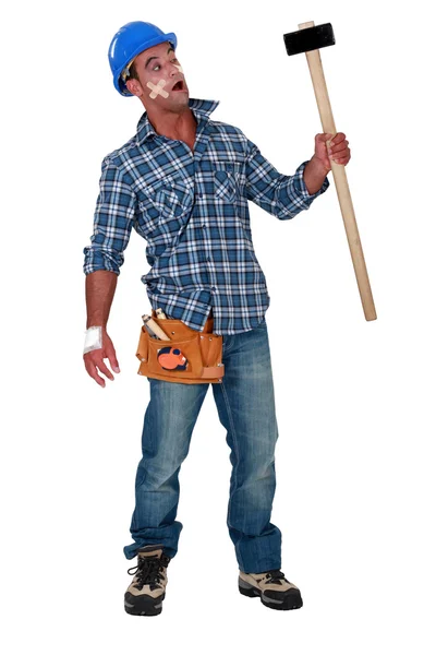 Injured workman with mallet in hand Stock Image