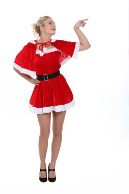 Gorgeous blonde in christmas outfit pointing to her side clipart