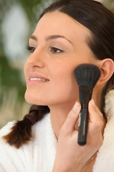 Mulher aplicando blush com uma escova — Fotografia de Stock