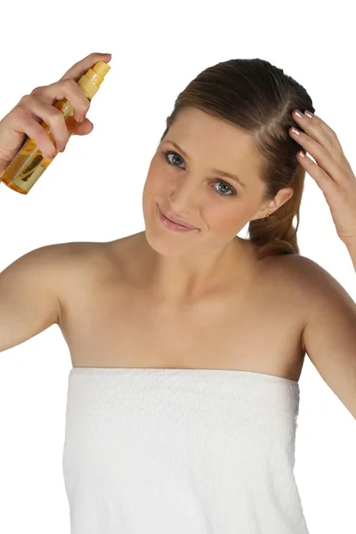 Mujer rociando acondicionador en su cabello — Foto de Stock