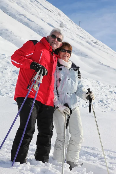 Senior koppel wandelen in de sneeuw — Stockfoto