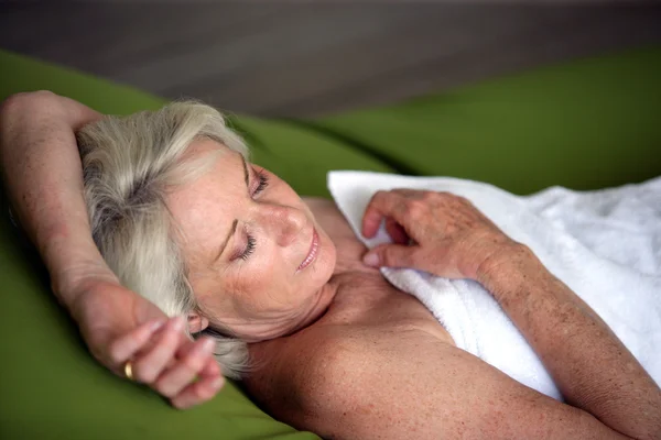 Donna anziana addormentata in un asciugamano — Foto Stock