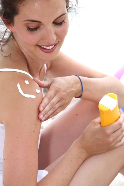 Женщина наносит солнцезащитный крем — стоковое фото