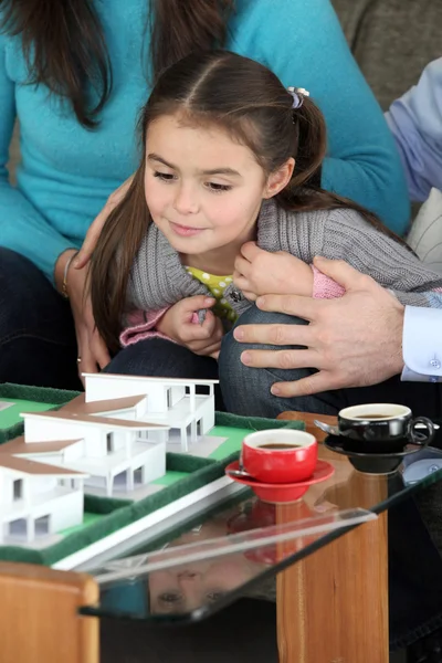 Mädchen schaut sich Modell des zukünftigen Hauses an — Stockfoto