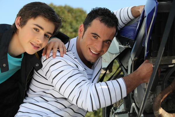 Vater und Sohn arbeiten am Motorrad — Stockfoto