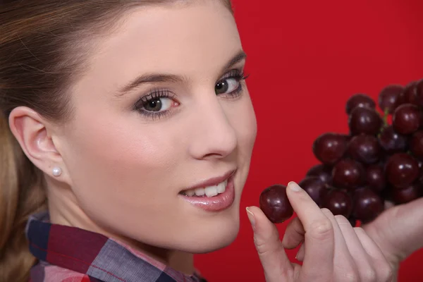 Donna con grappolo d'uva rossa — Foto Stock
