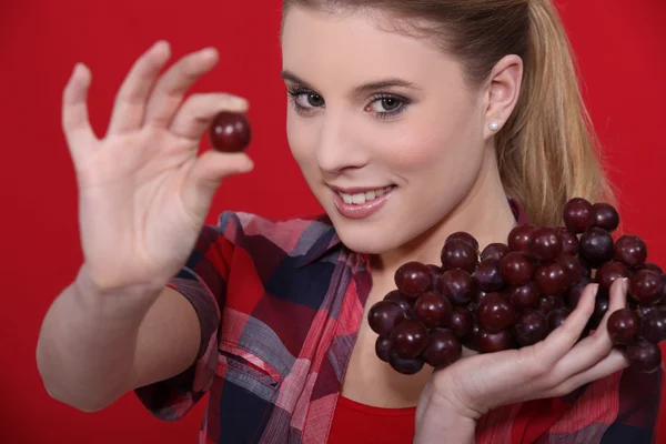Mulher atraente comendo uvas — Fotografia de Stock