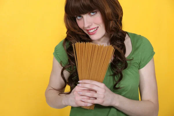 Vrouw bedrijf ruwe spaghetti — Stockfoto