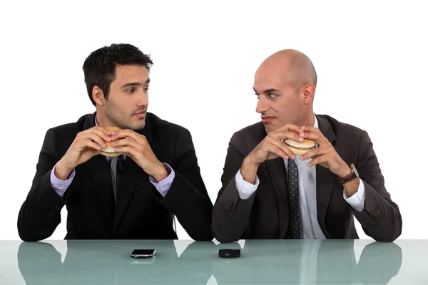 Duo de hombres de negocios comiendo hamburguesa — Foto de Stock