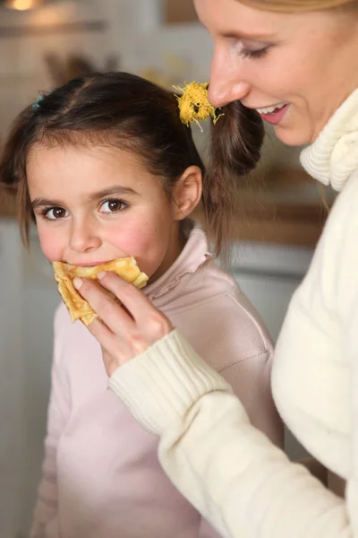 Mother giving her daughter a snack — Stock Photo, Image