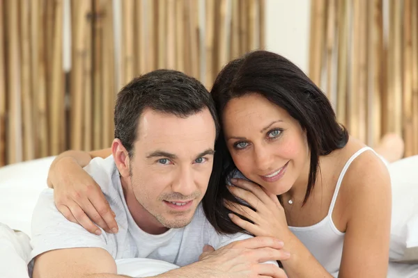 Couple lying on a bed — Stock Photo, Image