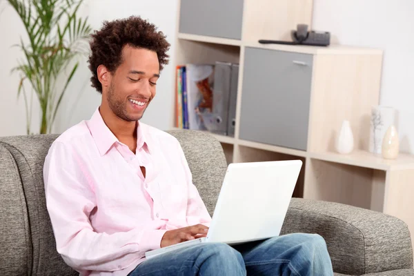 Man on couch with computer — Stock Photo, Image