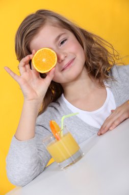 Girl covering her eye with orange slice clipart