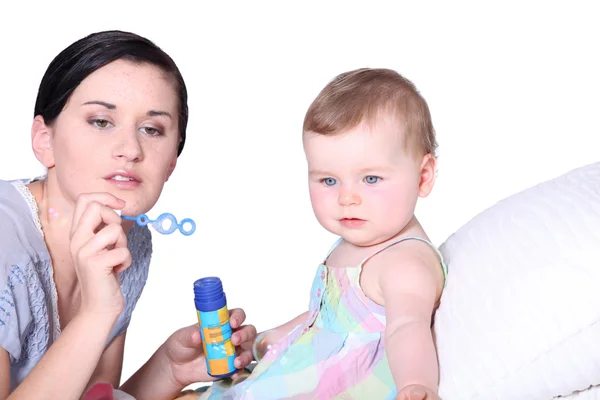 Mamma med barn blåsa bubblor — Stockfoto
