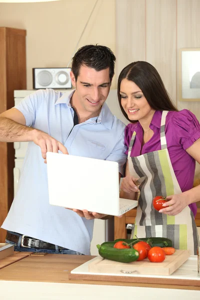 Couple cuisine avec un ordinateur portable — Photo