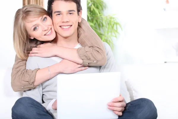 Lyckliga paret kramas samtidigt surfa på internet — Stockfoto