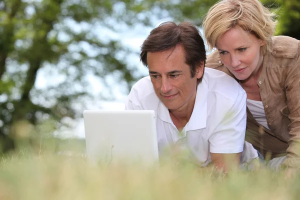 Casal com laptop ao ar livre — Fotografia de Stock