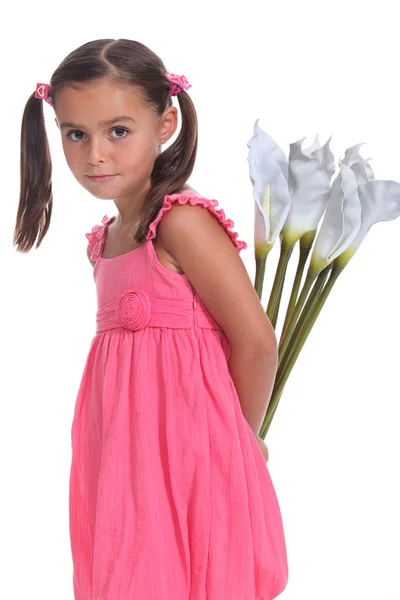 Girl with flowers behind back — Stock Photo, Image