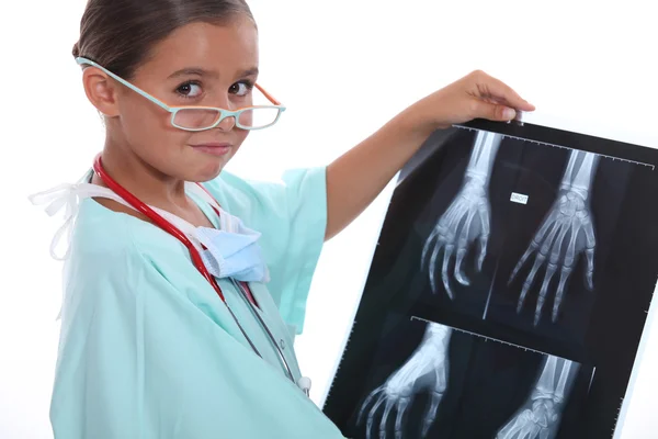 Genç kız bir x ışını inceleyerek Hastanesi scrubs içinde giyinmiş — Stok fotoğraf