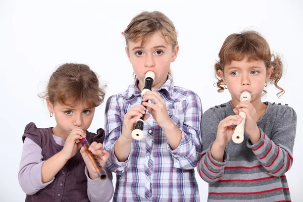 Three young girls playing the recorder — Stock Photo, Image