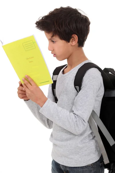 Маленький хлопчик носить рюкзак і читає книгу — стокове фото