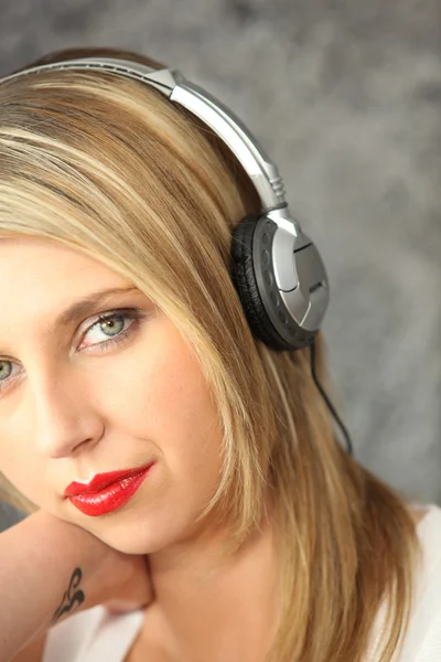 Kvinna lyssnar på musik med sina hörlurar — Stockfoto