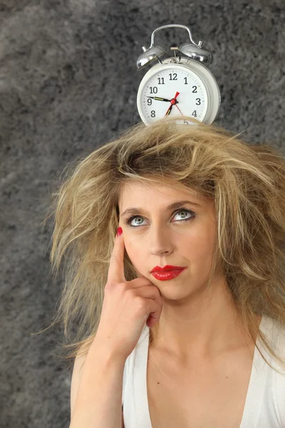 Young woman with a clock on her head — Stock Photo, Image