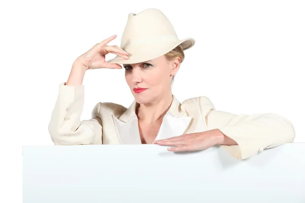 Krem renkli şapka ve mesaj panosu ile durdu ceket giyen kadın — Stok fotoğraf