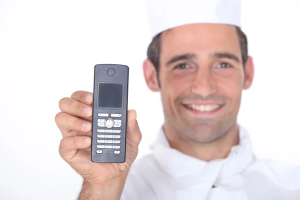 Шеф-повар держит мобильный телефон — стоковое фото
