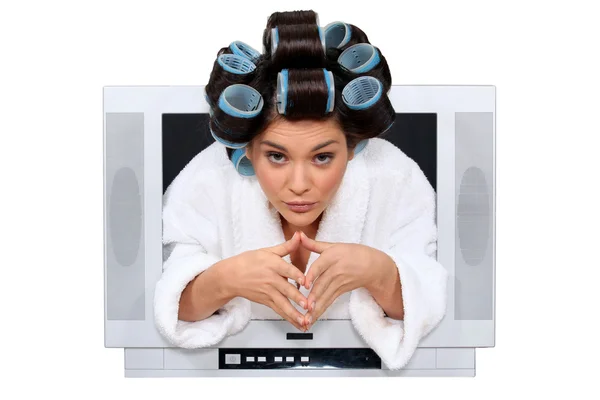 Mulher com rolos no cabelo escapando da televisão — Fotografia de Stock