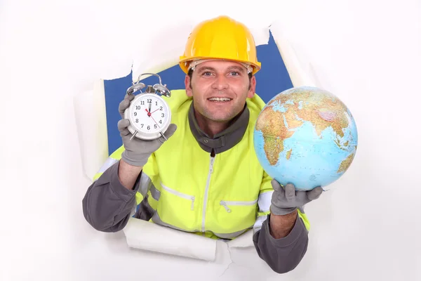 Craftsman holding a clock and a globe — Stock Photo, Image