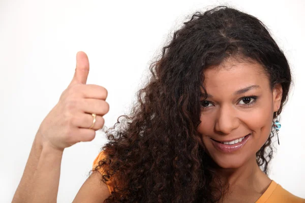 Женщина с вьющимися волосами дает большой палец — стоковое фото