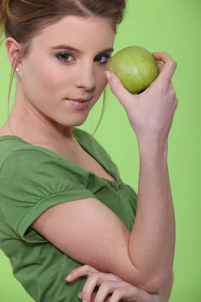 Mulher segurando maçã verde contra rosto — Fotografia de Stock