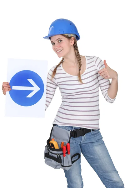 Smiling woman showing road sign — Stock Photo, Image