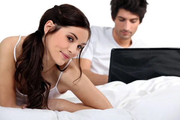 Couple with a laptop on a bed — Stock Photo, Image