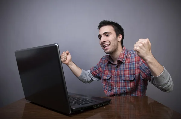 Joyful young man with laptop — Stock Photo, Image