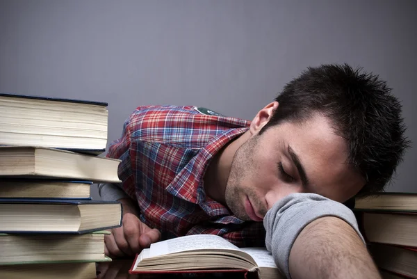 Молодой человек спит на книгах Стоковая Картинка