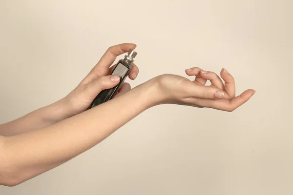 Mujer aplicando perfume en su muñeca — Foto de Stock