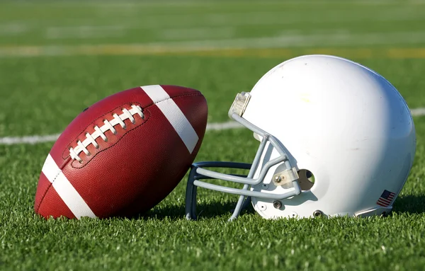 Футбол и шлем на поле — стоковое фото