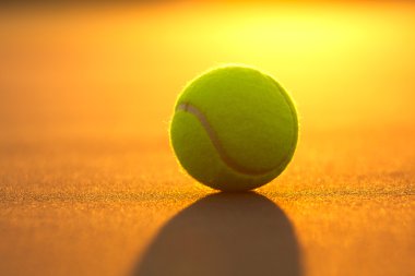 Tennis Ball on the Court at Sunset clipart