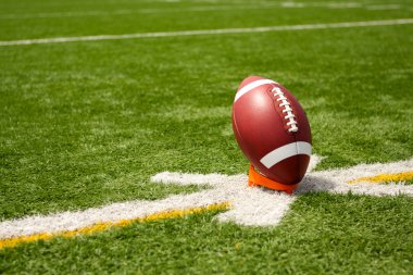 American Football teed up for kickoff clipart
