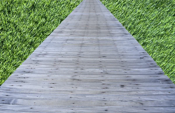Oude houten brug op gras achtergrond — Stockfoto