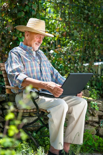 Sénior com um laptop — Fotografia de Stock