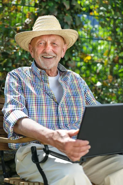 Senior con un computer portatile — Foto Stock