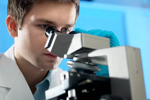 Επιστήμονας εξετάζει μικροσκόπιο — Φωτογραφία Αρχείου