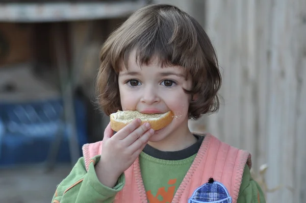 Kind met een sneetje brood Stockafbeelding