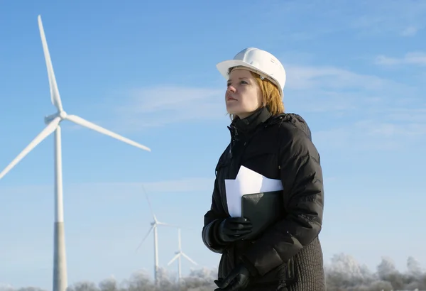Vrouw ingenieur of architect met witte veiligheid hoed en wind turbines op rug — Stockfoto