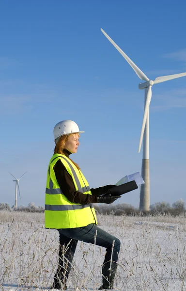 Vrouw ingenieur of architect met witte veiligheid hoed en wind turbines op rug — Stockfoto
