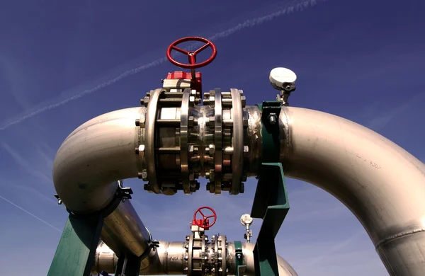 Промышленная зона, стальные трубопроводы и клапаны против голубого неба — стоковое фото