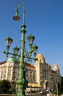 Street lamp with a beautiful hotel clipart